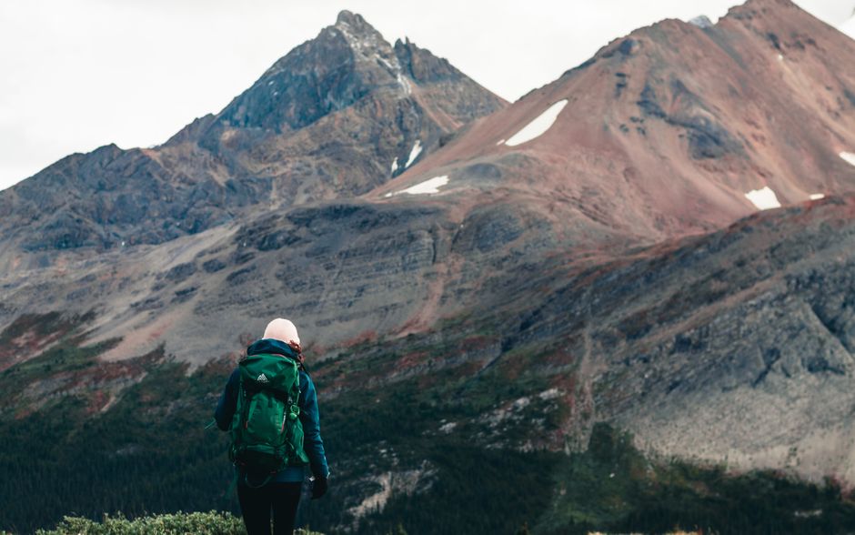 A person with a backpack hikes through stunning mountainous terrain, epitomizing adventure and outdoor exploration.
