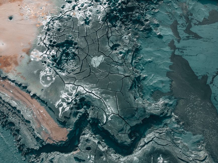 A dramatic aerial view captures the cracked and barren volcanic landscape in Iceland, showcasing unique geological formations.